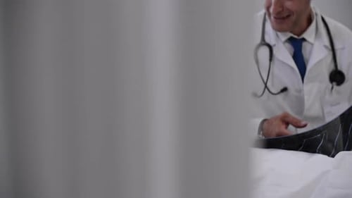 Doctor Explains X-ray to Child in Hospital Bed