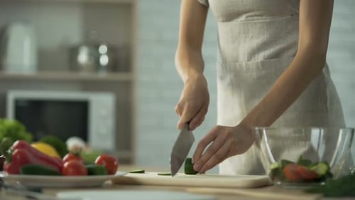 Woman Slicing Cucumber for Healthy Salad Preparation
