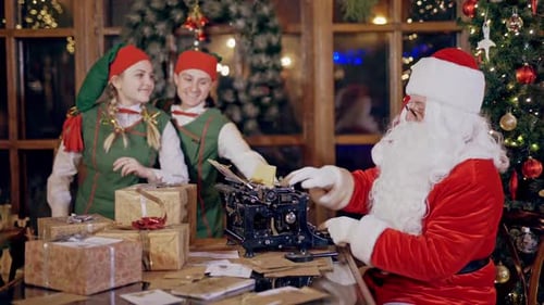 Happy elves in green costumes and Santa in his traditional red suit.