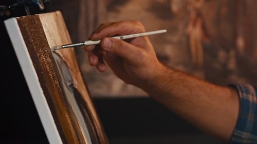 Man Artist Paints with Brush Strokes of Black Paint Oil
