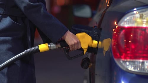 Woman Fills Gasoline Car. Hand Close Up