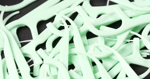 Pile of Light Green Dental Flossers Close Up