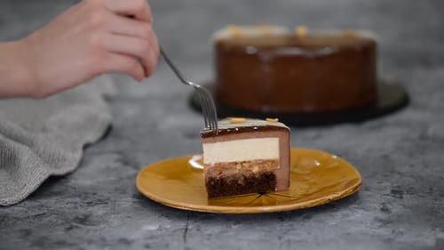Fork Cutting Slice of Rich Chocolate Layer Cake