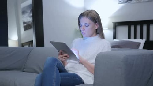 Woman Using Tablet on Couch in Bright Room