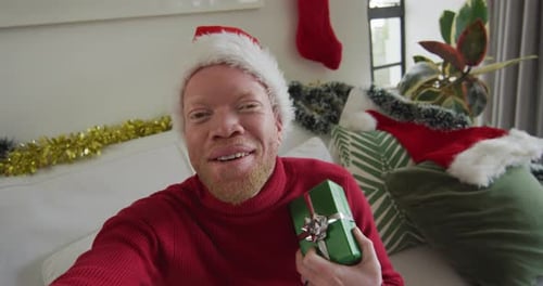 Festive Young Adult with Gift on Christmas Video Call