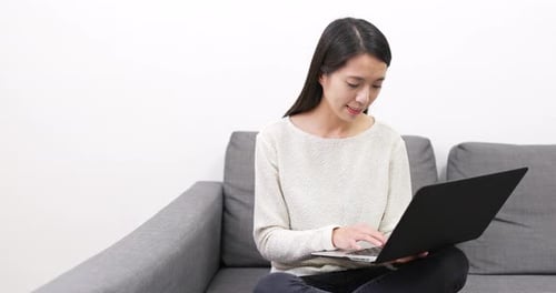 Woman Using Laptop Computer While Sitting on Couch