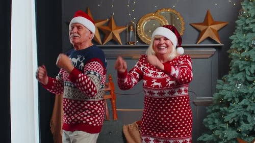 Senior Couple Dancing in Christmas Sweaters at Home