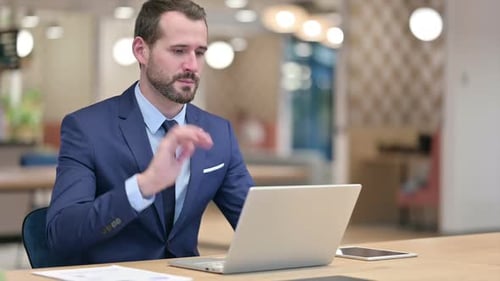 Businessman Doing Video Call on Laptop in Office