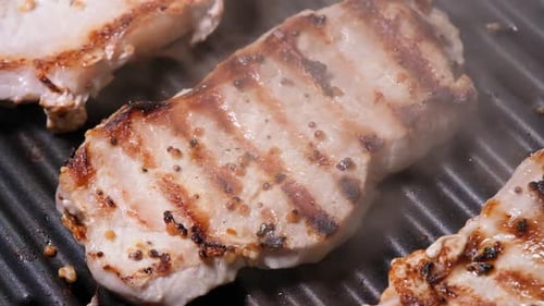 Close Up View on Meat with Golden Crust is Fried on an Electric Grill Close Up