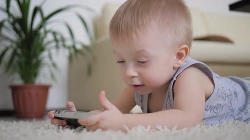 Happy Infant Playing on Phone at Home