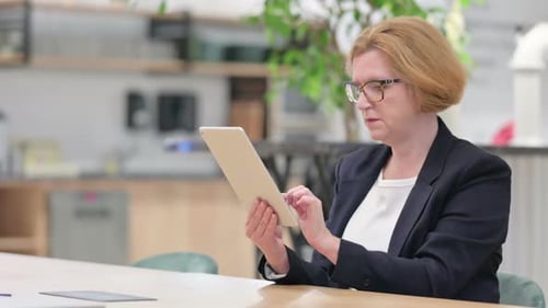 Serious Businesswoman Using Tablet in Office