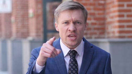 Man in Suit Gesturing and Talking Aggressively