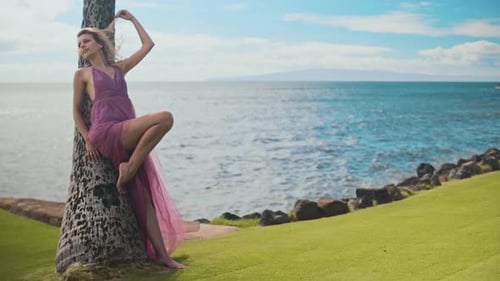 Elegant Woman in Purple Dress Posing on Beach