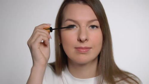 Woman applies mascara, beauty close up shot