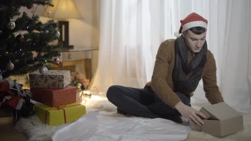 Young Adult Wrapping Christmas Gift Indoors