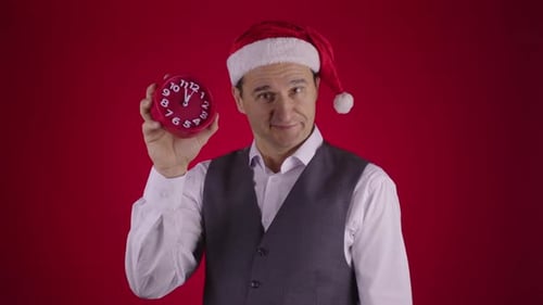 Man Wearing Santa Hat Holds Clock Nearing Midnight