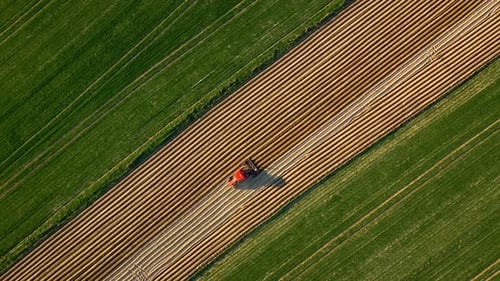 Aerial View of Tractor Performs Seeding on the Field