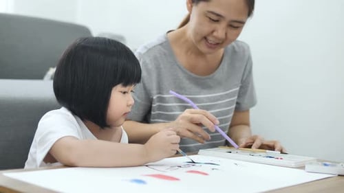 Child and Adult Painting Together at Home