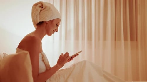 Woman in Bed Using Mobile Phone After Bath