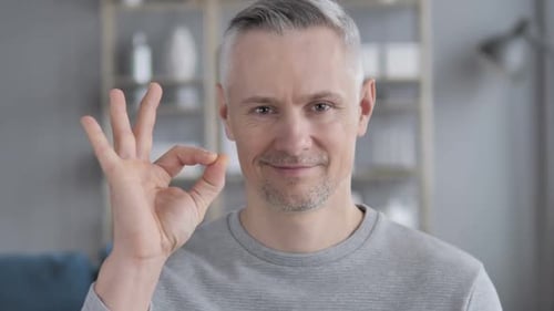 Man Gives OK Hand Sign Indoors