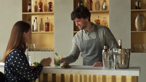 Bartender Serves Woman Cocktail in Stylish Bar
