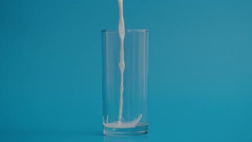 Movimiento superlento de gotas de leche que caen en vidrio transparente