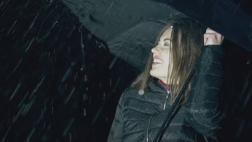 Happy Woman with Umbrella Enjoys Rain at Night Slow Motion
