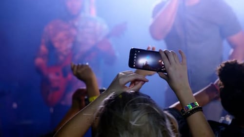 Excited Crowd Watching Live Music Concert at Night