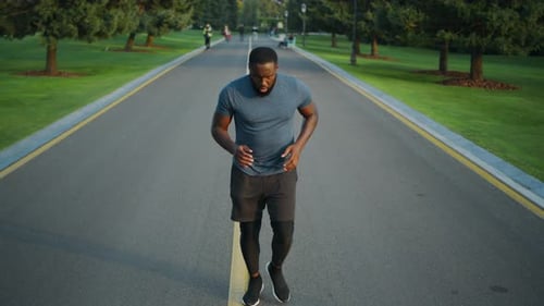 Jogger Starting To Run in Park. Concentrated Sportsman Jogging Outdoors
