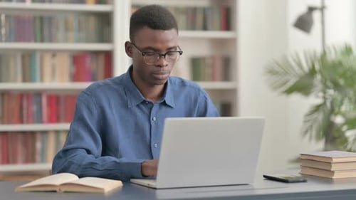 Young Adult Working on Laptop at Desk Indoors