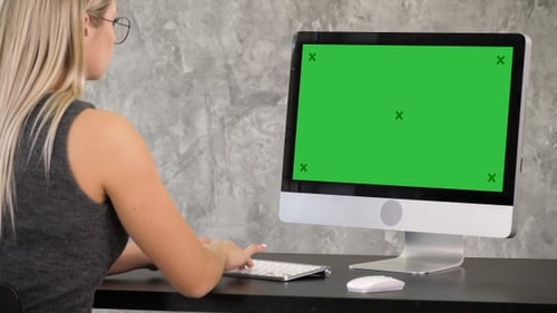 Young Woman Working on Computer with Green Screen