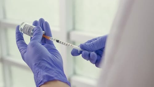 Nahaufnahme Eine Durchstechflasche mit dem COVID-19-Coronavirus-Impfstoff wird von einem Wissenschaftler verwendet