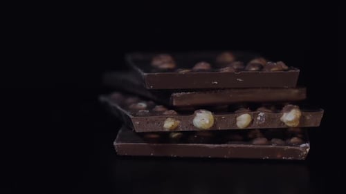 Dark Chocolate Blocks with Nuts Details Slow Close-up Macro. Chocolate Bars