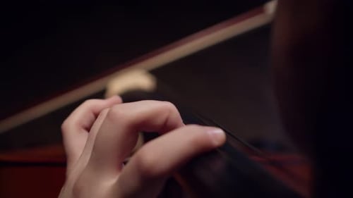 Female Musician Plays Classical Music on Cello Fingering the Strings Closeup