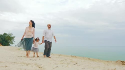 Family walking along beautiful beach on overcast day