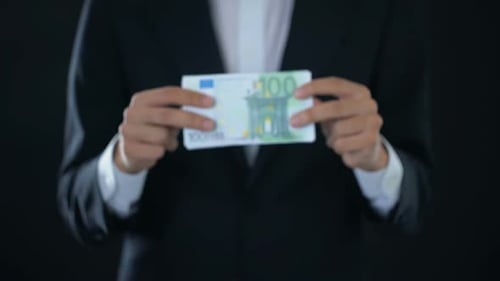 Empresario mostrando billetes en euros, moneda europea, oferta de crédito, economía
