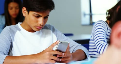 Student using mobile phone in classroom
