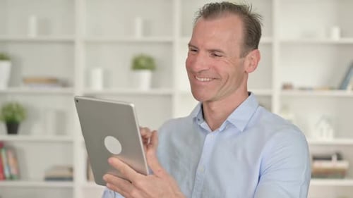 Mature Man Using Tablet For Video Call