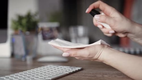 Handheld video of woman cleaning keyboard in the office. Shot with RED helium camera in 8K.