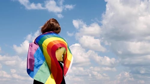 Young Adult with Rainbow Flag on a Sunny Day