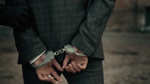 The Police Take the Handcuffed Prisoner To the Prison. Detention of a Suspect. Back View