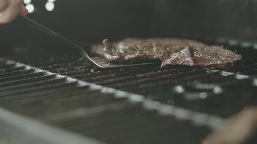 Juicy Steak Grilling on Metal Grates Indoors