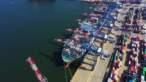 Container ship in export and import business and logistics. Shipping cargo to harbor by crane. Water