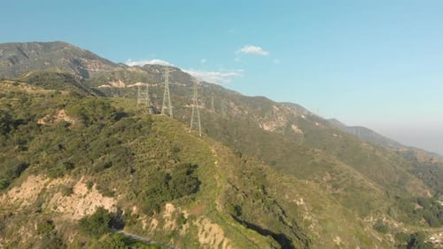 Antenne von Stromleitungen auf einem grünen Berg