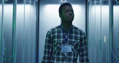 Young adult in server room, mid shot