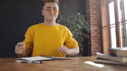 Young Adult Taking Notes and Stretching Inside