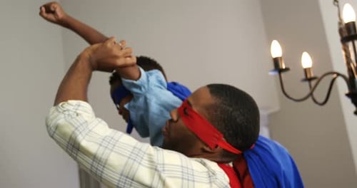 Father and Son Playing Superheroes at Home