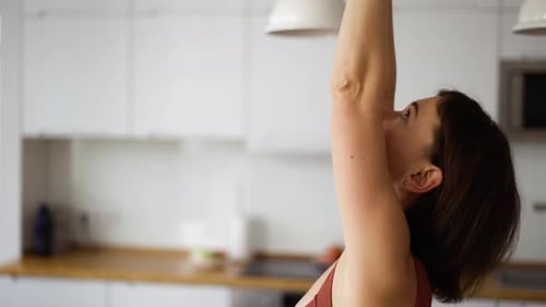 Woman Stretching Arms in Bright Home Interior