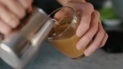 Barista making latte art in specialty coffee shop.
