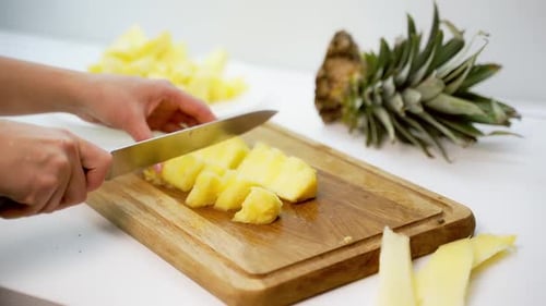 Cutting a Pineapple on a Wooden Board